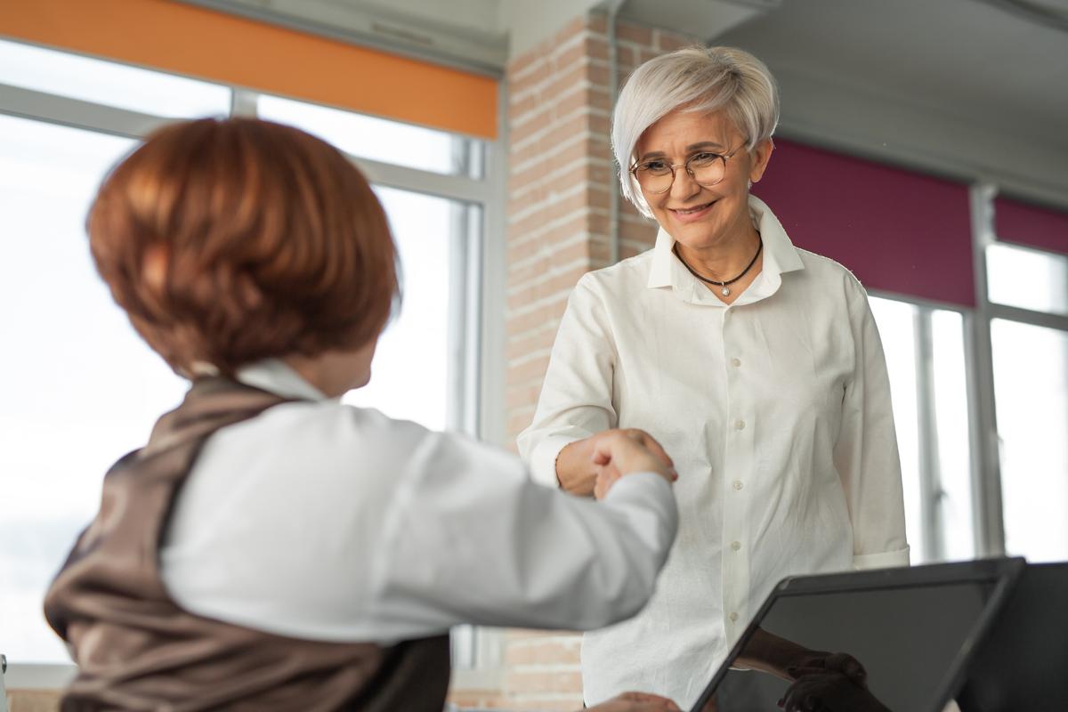 Mature woman shaking hands with a female financial expert