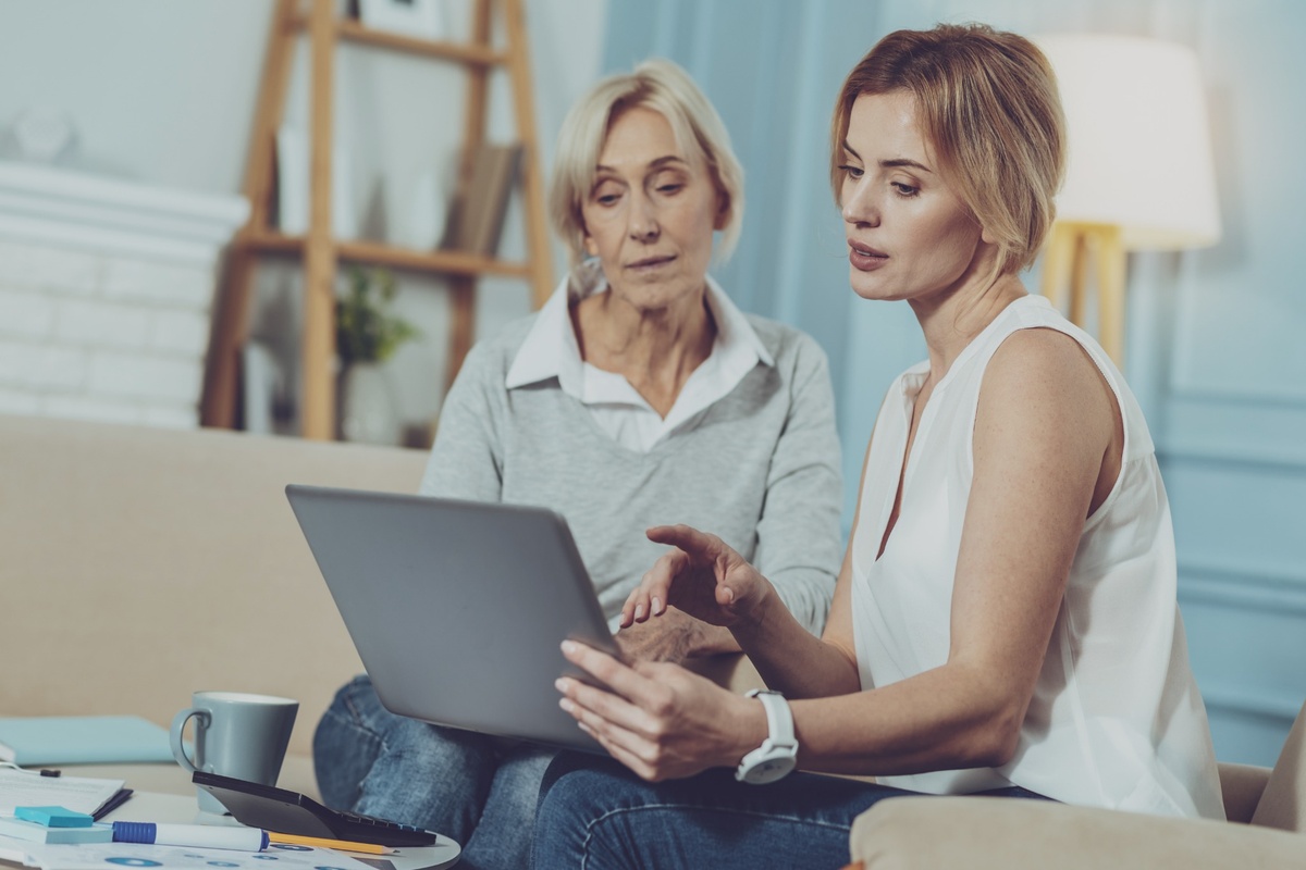 Female financial adviser and senior female client looking at a laptop