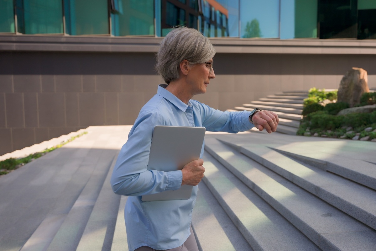 Middle-aged woman looking anxiously at her watch